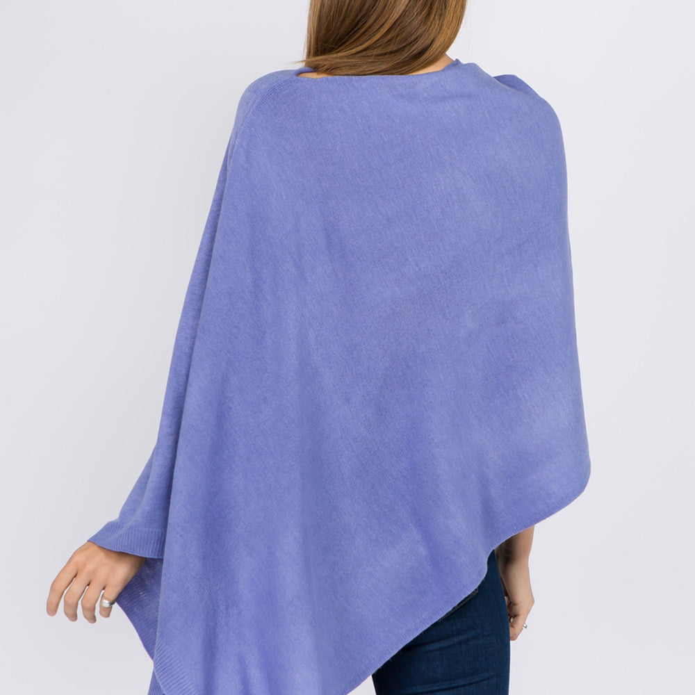 Back facing young woman wearing a periwinkle colored poncho